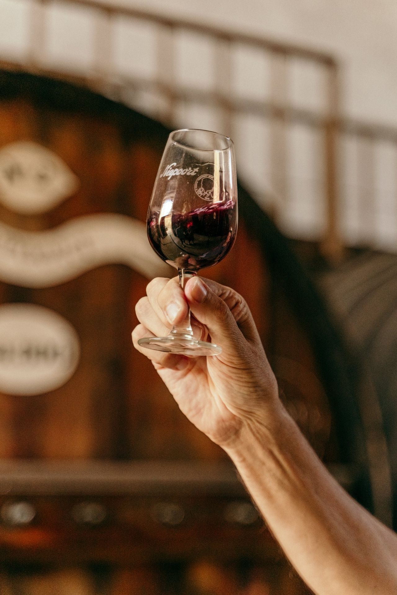 A glass of port in front of an old cask